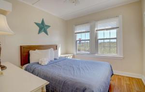 旧奥查德比奇Waves Oceanfront Resort的一间卧室设有蓝色的床和2个窗户。