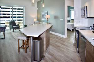 劳德代尔堡Landing Modern Apartment with Amazing Amenities (ID2666X14)的厨房以及带桌子和沙发的客厅。
