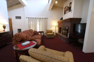 班戈Fireside Inn and Suites Bangor的带沙发、电视和壁炉的客厅