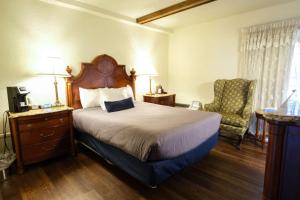 班戈Fireside Inn and Suites Bangor的配有一张床和一把椅子的酒店客房
