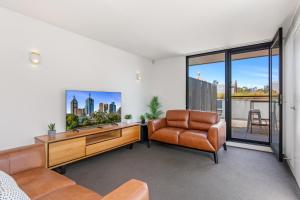 墨尔本Fantastic 3-Bed Home by Melbourne Uni & Zoo的一间带电视和椅子的客厅
