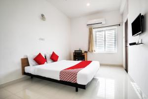 PīlameduFlagship 82361 Black Pearl Residency的白色卧室配有红色枕头的床