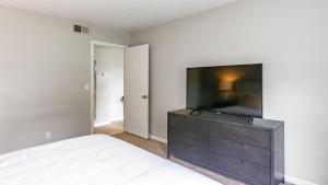 纳什维尔Landing Modern Apartment with Amazing Amenities (ID4935X54)的一间卧室配有一张床,在梳妆台上配有一台平面电视