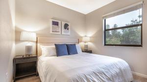 迈尔斯堡Landing Modern Apartment with Amazing Amenities (ID8214X04)的一间卧室配有一张带蓝色枕头的床和一扇窗户。