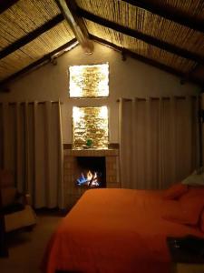 派帕Linda mini casa campestre con Jacuzzi, chimenea...的一间卧室设有一张床和一个壁炉