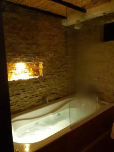 派帕Linda mini casa campestre con Jacuzzi, chimenea...的砖墙客房内的浴缸