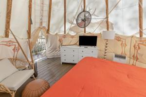 StantonFurnished Teepee/Glamping/Kayak Ramp/King Bed的一间卧室,配有一张床,帐篷内设有一个钟