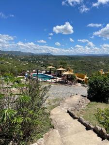 维拉卡洛斯帕兹Cabañas Terrazas del Sol的田间中带游泳池的度假村