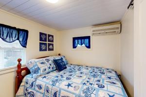 大洋城The Gull's Nest at Isle of Wight的卧室配有蓝色和白色的床和窗户。