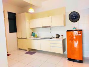 新山JB Bukit Indah Skyloft Suites的一间厨房,在房间内配有橙色冰箱