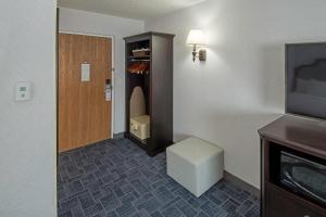 泽西市Holland Hotel Free Parking Jersey City的一间设有门、凳子和电视的房间