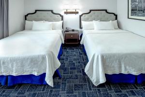 泽西市Holland Hotel Free Parking Jersey City的配有白色床单的酒店客房内的两张床