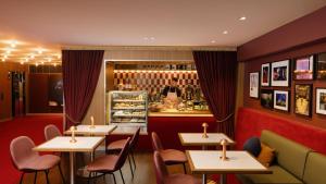 悉尼悉尼蓝塞瑞拉莫特酒店的配有桌椅的餐厅,柜台后面有一个人