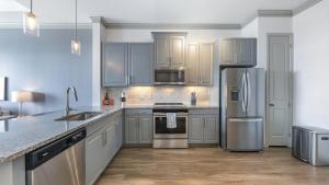 加兰Landing Modern Apartment with Amazing Amenities (ID7989X65)的厨房配有灰色橱柜和不锈钢用具