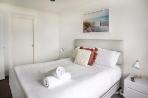 黄金海岸South Pacific Plaza - Official的卧室配有白色的床和2条毛巾