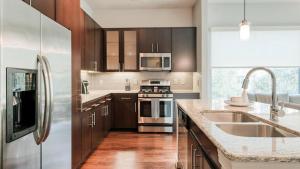 兀兰Landing Modern Apartment with Amazing Amenities (ID5143X81)的厨房配有不锈钢用具和木柜
