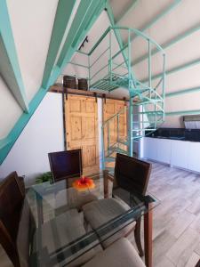 Alto BoqueteCabaña puente Wilson的一间带玻璃桌和螺旋楼梯的用餐室