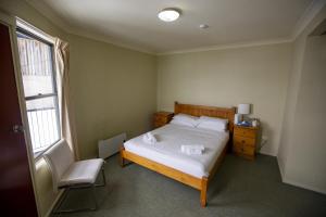 Charlotte PassLucy Lodge的卧室配有床、椅子和窗户。