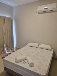 布希奥斯Villa do Aconchego apartamento super novo的白色床罩的房间里的一个床位