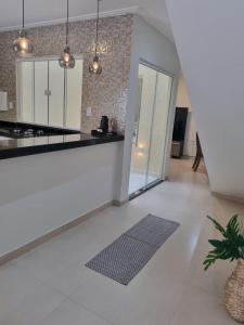布希奥斯Villa do Aconchego apartamento super novo的厨房铺有白色地板,配有台面