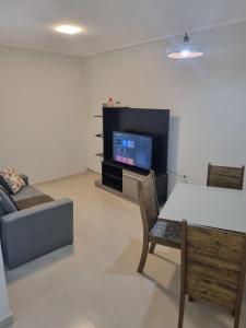 布希奥斯Villa do Aconchego apartamento super novo的客厅配有电视、桌子和沙发