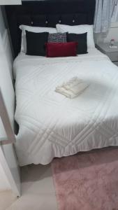 阿雷格里港Hotel Palace的一张白色的床,上面有一件浴袍