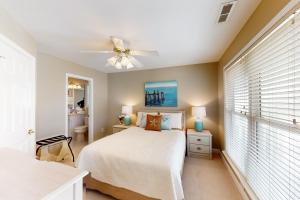 海洋岛海滩The Carolina Shell的一间卧室配有一张床和吊扇