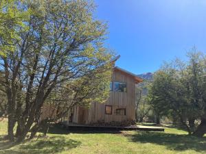 塞罗别墅卡斯蒂略Acogedora casa en bosque Cerro Castillo cercana Parque的前面有树木的小木屋