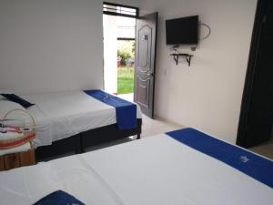 比利亚维哈Cosmos Tatacoa Hotel的一间设有两张床和一台电视的房间