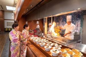上天草Ooedo Onsen Monogatari Amakusa Hotel Kameya的一群厨师在厨房里准备食物