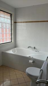 查尔斯敦Charlestown TownHouse的白色的浴室设有浴缸和卫生间。