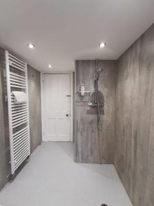 贝克斯希尔William Morris, Spacious ground floor lux double bedroom的带淋浴的浴室和白色门