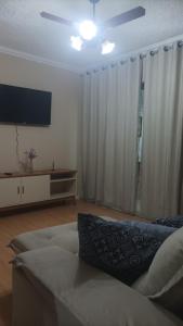 大伊瓜巴Morada do Sol de Iguaba AP 2 qts的带沙发和平面电视的客厅