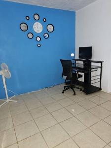 克里斯琴斯特德Veronica's Tropical Oasis的办公室,带桌子,蓝墙,带时钟