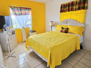 克里斯琴斯特德Veronica's Tropical Oasis的一间卧室配有一张黄色床罩的床