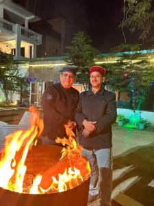 瑞诗凯诗Shivansh Inn Resort的两个男人站在火坑前
