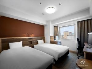 仙台仙台大和鲁内酒店的酒店客房设有两张床和窗户。