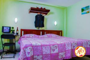 伊基托斯ALLISON HOTEL的一间卧室配有一张带粉色毯子的床