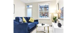 特威克纳姆City Elegance: Spacious 2BR for Urban Comfort的客厅配有蓝色的沙发和桌子