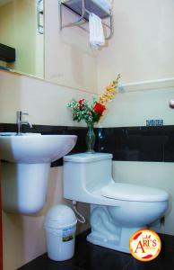 伊基托斯ALLISON HOTEL的浴室设有卫生间、水槽和花瓶。