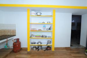 蓬蒂切里SJ Villa的一间有餐具的房间的黄色架子