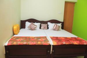 科钦Oshin Home Stay的一间卧室配有带枕头的床