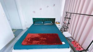 HoatDong Thanh Ecolodge Homestay的一间卧室配有蓝色的床和粉红色的窗帘