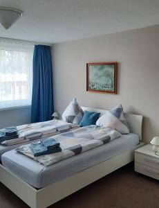 达沃斯Holiday Apartment Davos Residence的一间卧室配有一张带蓝色窗帘的大床