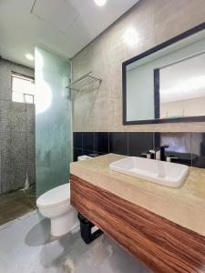 卢纳将军城Siargao Bed and Brewery的一间带水槽、卫生间和镜子的浴室