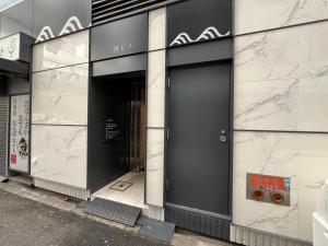 大阪ELLE Namba 7的建筑的一侧有一道黑色的门