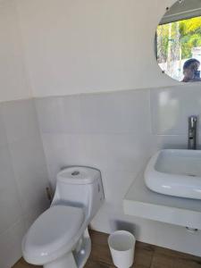 El GuayaboCasa Mochileros Anonimos的白色的浴室设有卫生间和水槽。