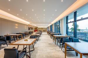 珠海珠海桂山岛智选假日酒店的餐厅设有桌椅和大窗户。