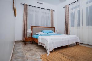 金贾MUTIMA VILLA的一间卧室设有一张床和一个大窗户