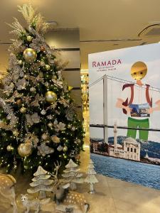 伊斯坦布尔Ramada By Wyndham İstanbul Taksim的商场里的圣诞树,带有标志